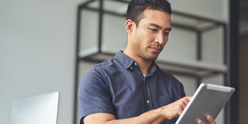Photo of an adult male looking at a computer tablet