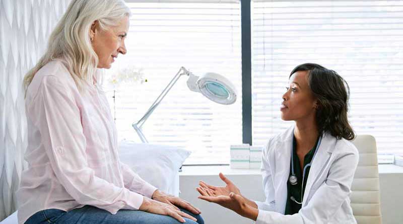 Elderly woman talking with her doctor