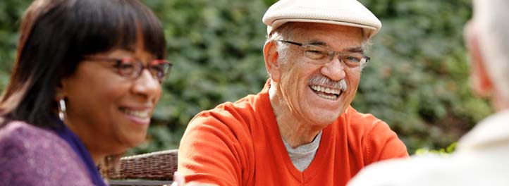 Elderly man with friends gathered together outdoors