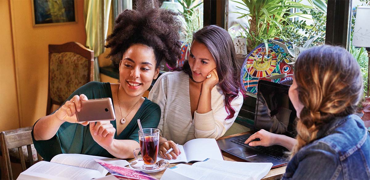 Photo of three women looking at a smartphone